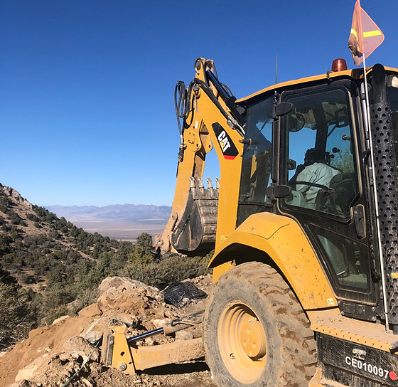 Backhoe cutting a drill pad on a Nevada ridgeline